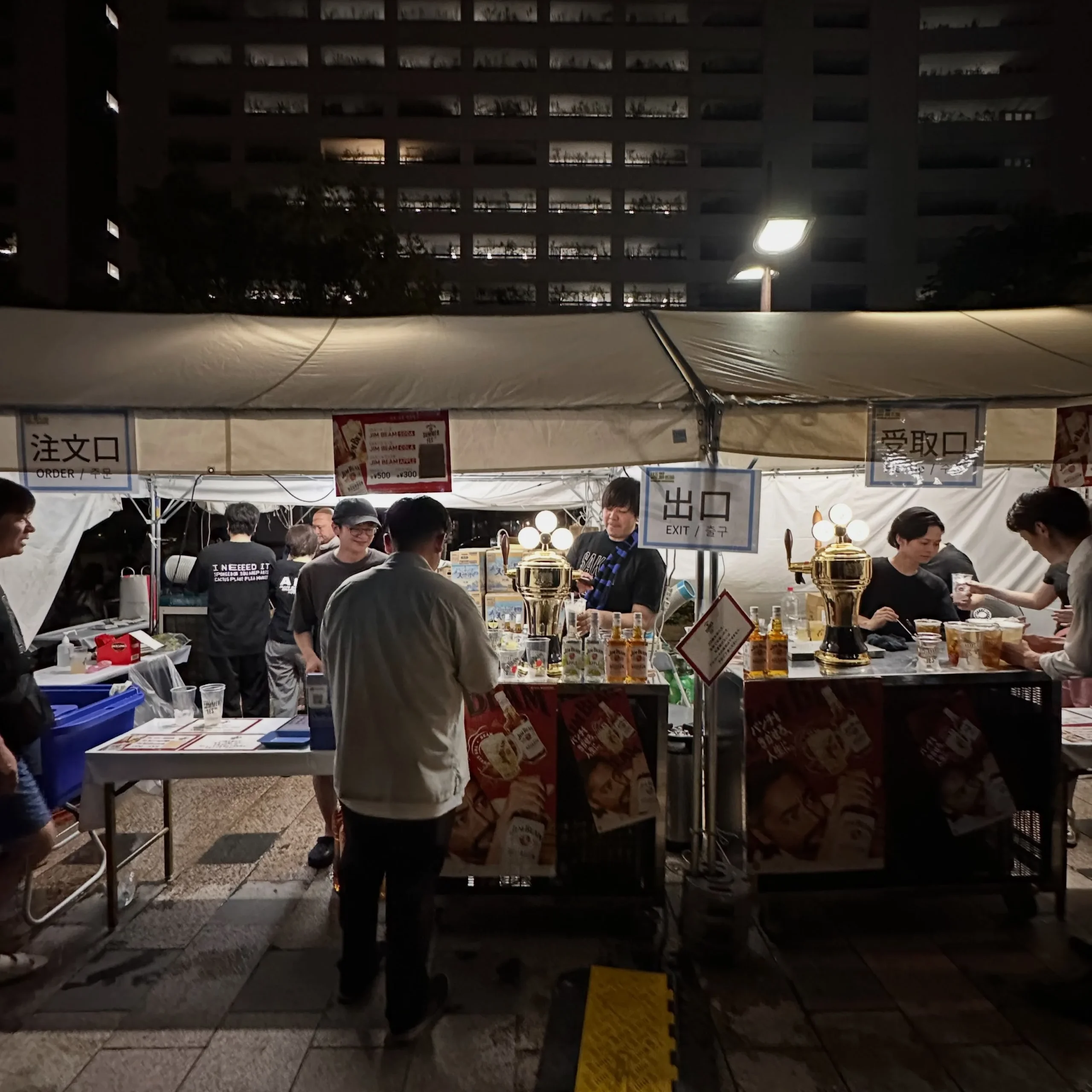日が暮れたジムビームフェスのドリンクブースと注文口