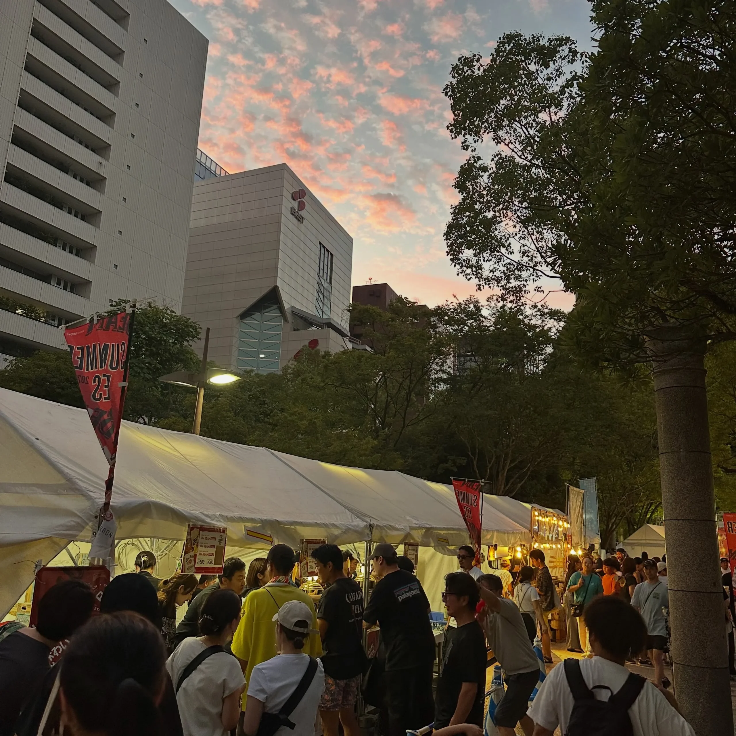 夕暮れの会場に伸びるドリンクブースの行列