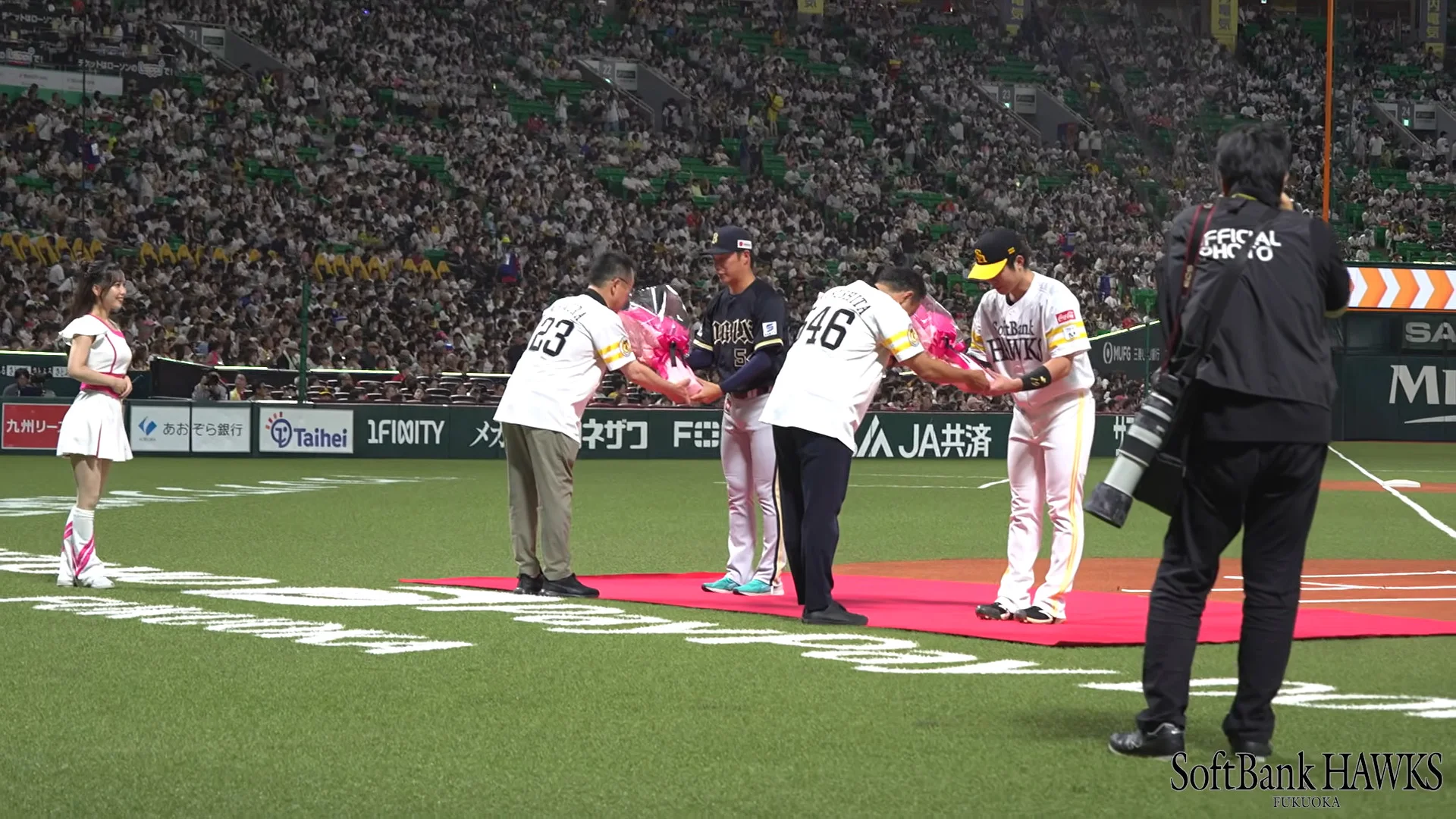 グラウンドで選手へ花束を贈呈する様子